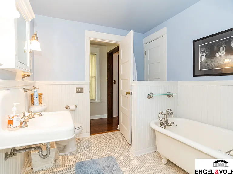 East end full spacious bathroom with clawfoot tub, wall hung porcelain sink, and Linen Closet