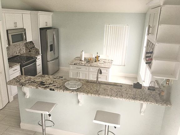 large kitchen with island, stain-less steel appliances, pantry, and wine-rack