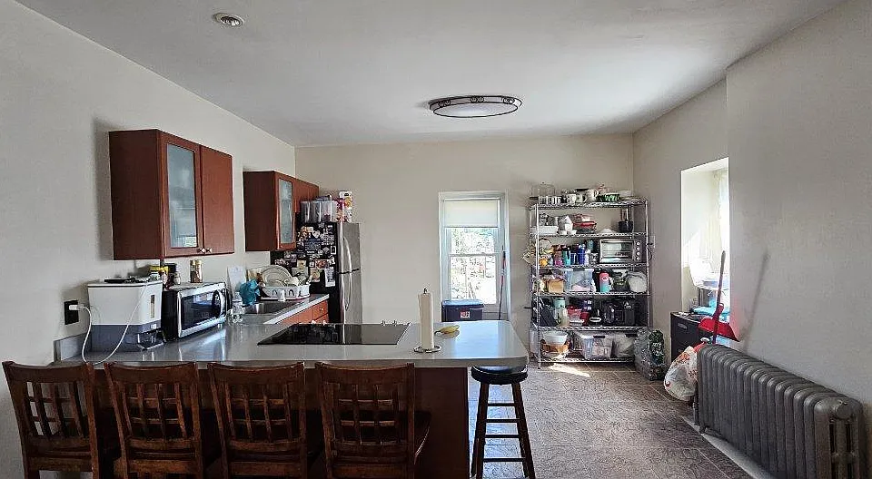 Open kitchen countertop chairs and appliances