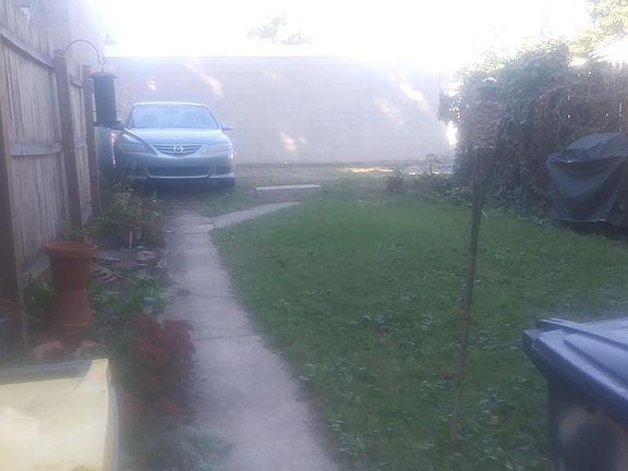 view of back yard and private parking spaces