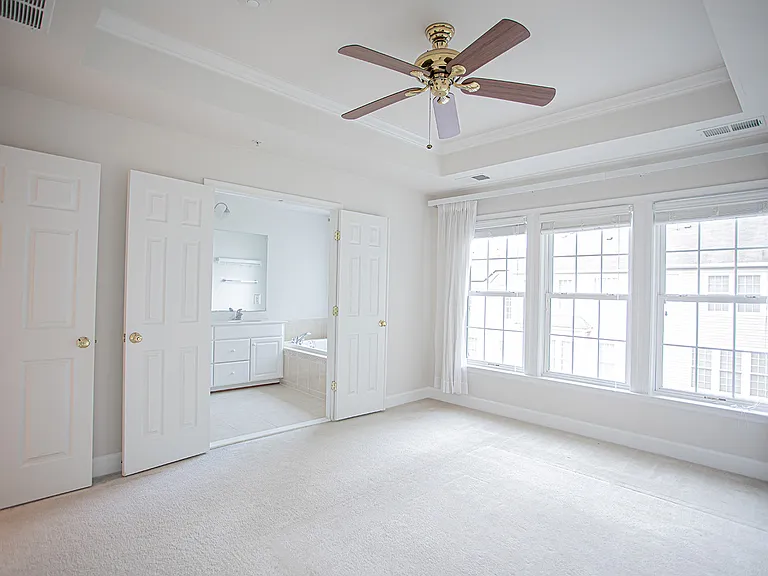 Airy and spacious Master Bedroom naturally flowing into a spa-like bathroom, featuring double doors leading to the bathroom
