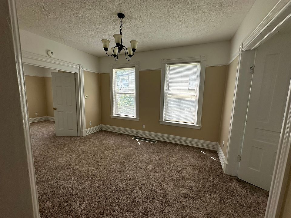 Large living room leads to 2 bedrooms with original wood doors.