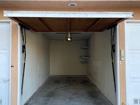 Single garage with storage shelves.