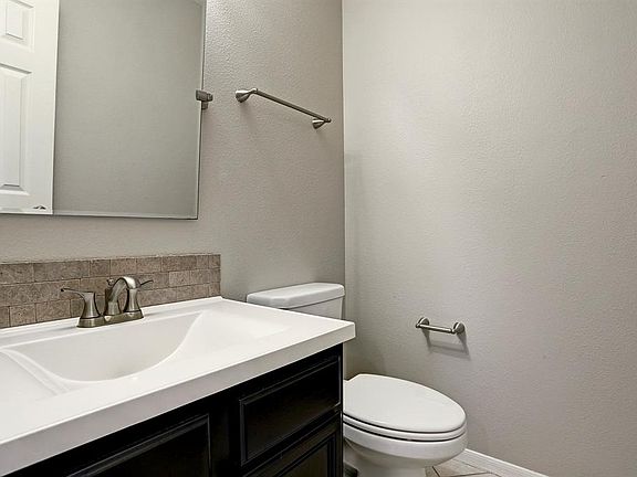 THE GUEST BATH WITH UPDATED VANITY & MIRROR. ALL TOILETS WERE REPLACED THROUGHOUT THE HOME IN JANUARY OF 2013.