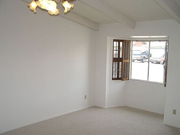 Open living room with vaulted ceilings and a lighted plantshelf