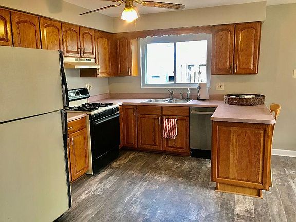 Large, fully-equipped kitchen with dishwasher. Looks out onto back deck and backyard.