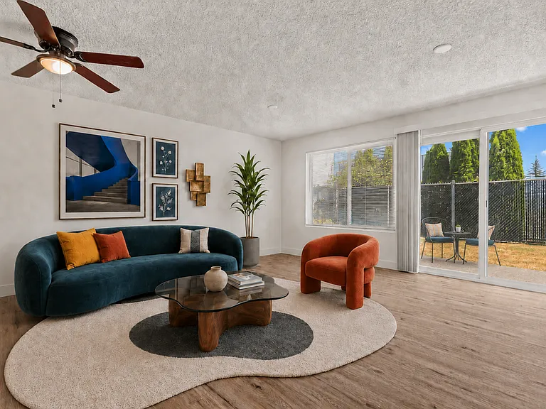 Bright, spacious living room with direct access to a private patio at Palisades Apartments in Tacoma.