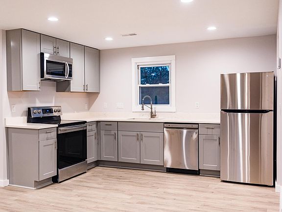 New kitchen with spacious cabinets, quartz countertops, and stainless steel appliances.