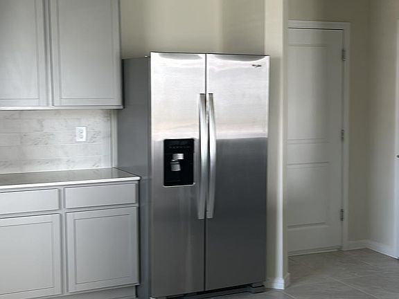 Brand new fridge and lots of cabinets for storage.