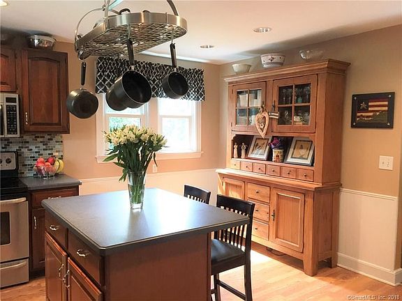 Kitchen with Corian Island and Counters-Laminate flooring-recessed lighting and pot rack