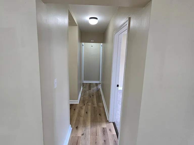 Hallway leading to laundry area, full bath, and all 3 bedrooms.