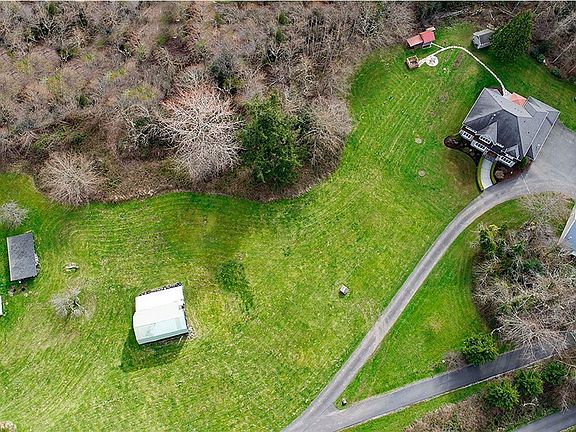 Aerial View Of The Estate. An Additional 820 Square Foot, 2 Bedroom/1 Bathroom Home Is Located At The Front Of The Property. A Large Rustic Barn Sits In The Middle Of A Vast Pastural Space. The Main Home With 3-Car Attached Garage Sits Far Back From The Road And Is Reached By A Private Driveway. A Heated & Insulated Detached Shop With Extra Large Bay Doors Sits Off To The Side Of The Home. And, A Generous Sized Well-House/Garden Shed And Chicken Coop Sit Off To The Opposite Side Of The Home. This Is A "Must See" Property!