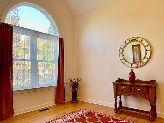 Formal living room has vaulted ceiling and beautiful view out large window.
