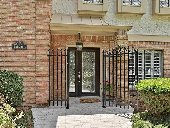 The stamped concrete sidewalk leads you to a beautiful leaded glass front door.