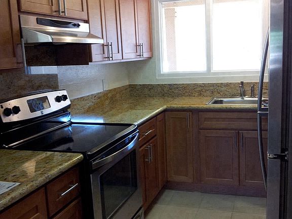 Kitchen furnished with refrigerator, oven/stove top, range, 