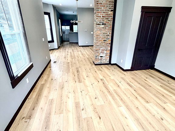 Family room with exposed original brick before entry into dining area