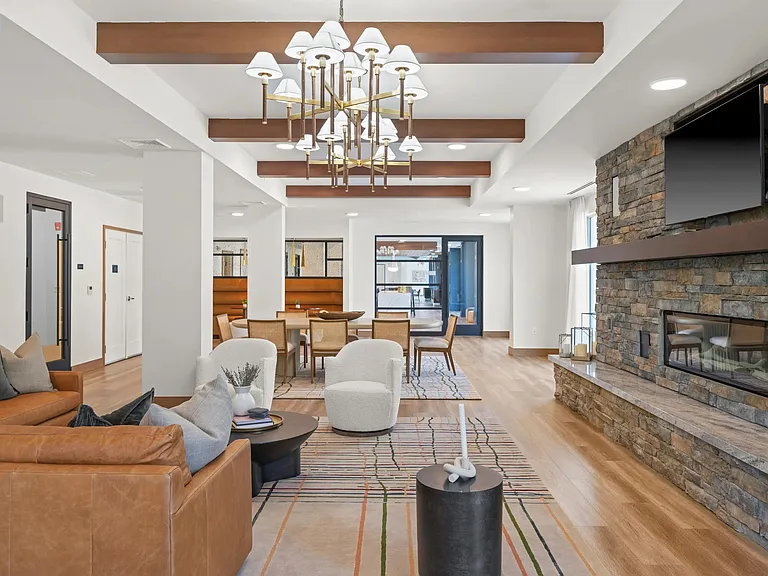 Multiple lounge areas with comfortable seating and a central fireplace create inviting spaces to relax.