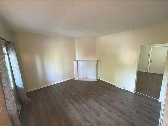 Light and bright Living room with new window treatments and new wood floors, freshly painted, deco fire place.