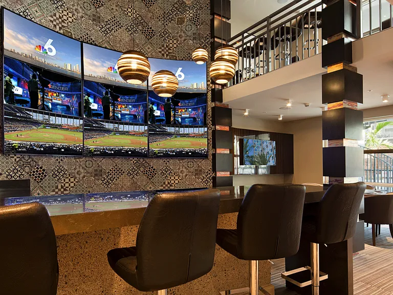 Hip sports lounge with flat screen TVs and bar-style seating