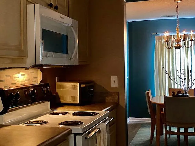 Kitchen with new microwave and various settings for night light with new backsplash and newly painted cupboards!