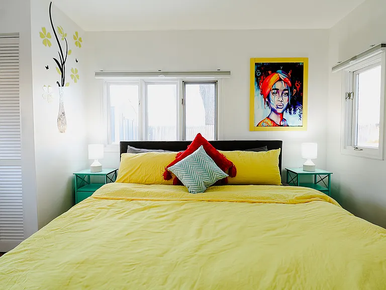 A bedroom designed with adequate lighting, creating a bright and welcoming space that enhances comfort and ambiance, perfect for both relaxation and reading.