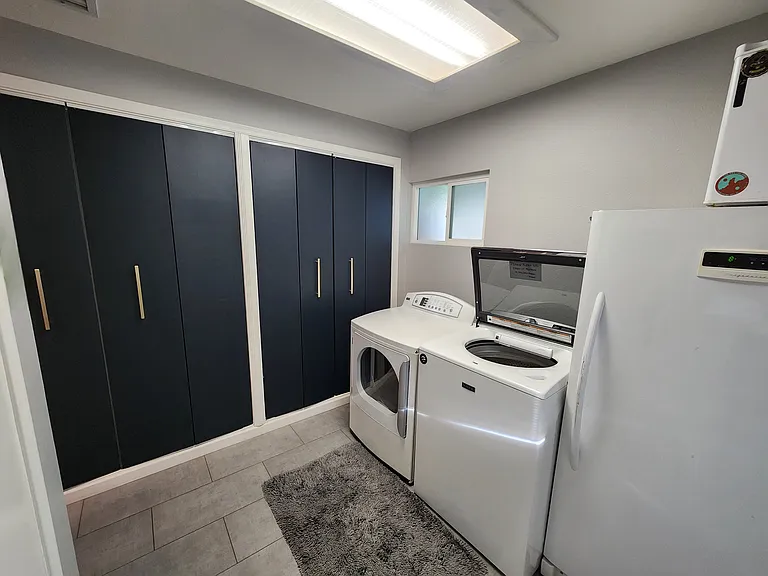 Laundry room features a high-efficiency washer and dryer and storage for extra pantry and cleaning supplies (2 cupboards are reserved for owner storage)