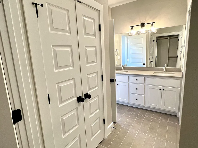 located in the master bathroom is a spacious storage closet adjacent to the walk in closet.