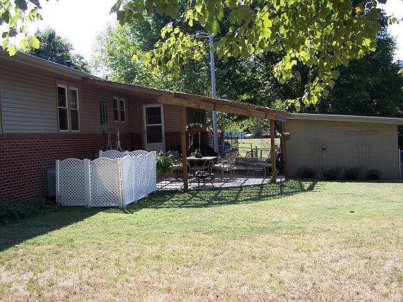 Mudroom door leads to patio with pergola & storage building