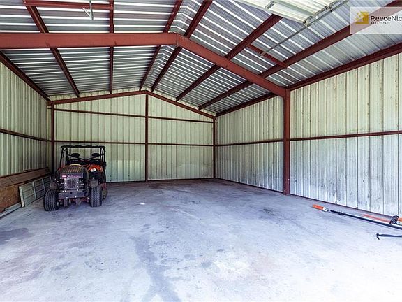 Inside the 40x30 Outbuilding/Garage that features concrete floor, 14 foot garage door, side door and enough space for 4+ cars!