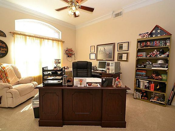 Study accented by double crown molding, recessed lighting and a ceiling fan with light fixture
