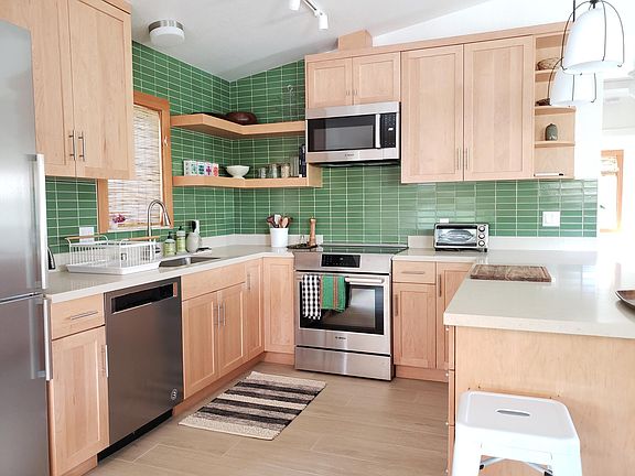 New modern kitchen drenched in natural light with beautiful high end natural wood cabinets. New high quality stainless steel appliances: dishwasher, microwave, refrigerator, self clean oven, and induction electric stove.