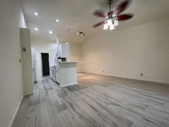 Open Plan Living room/Kitchen/dining area, with ceramic tile that looks like wood, and vaulted ceilings