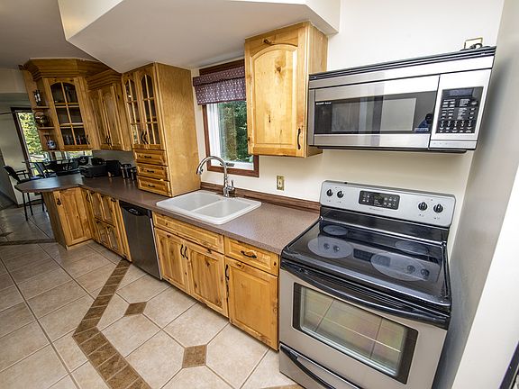 Another view highlights the appliances and octagon tiled floor pattern. The hanging wall photos include spotlight lighting features as well.