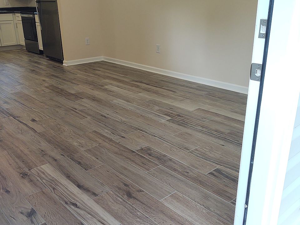 Open concept living room, dining area & kitchen tile flooring throughout the apartment.