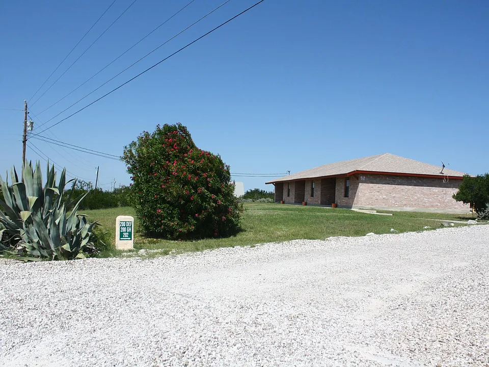 Triplex as seen from Houston Ave. and roadway leading to parking