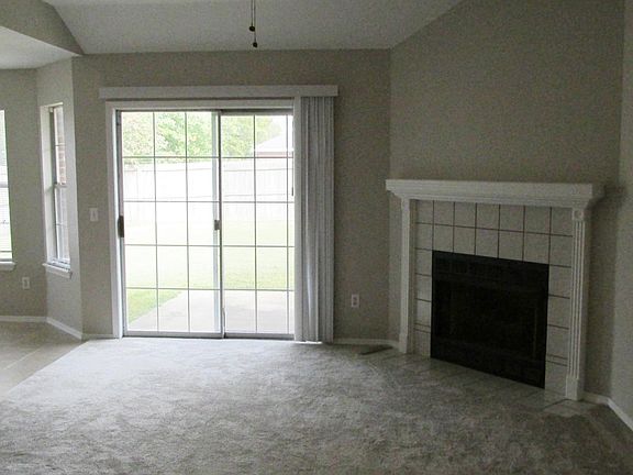 A view of the living room from the entryway. The sliding glass door leads to the back yard.
