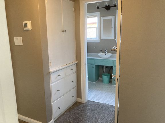View of hallway from the living room. Large linen closets on both side of the bathroom.