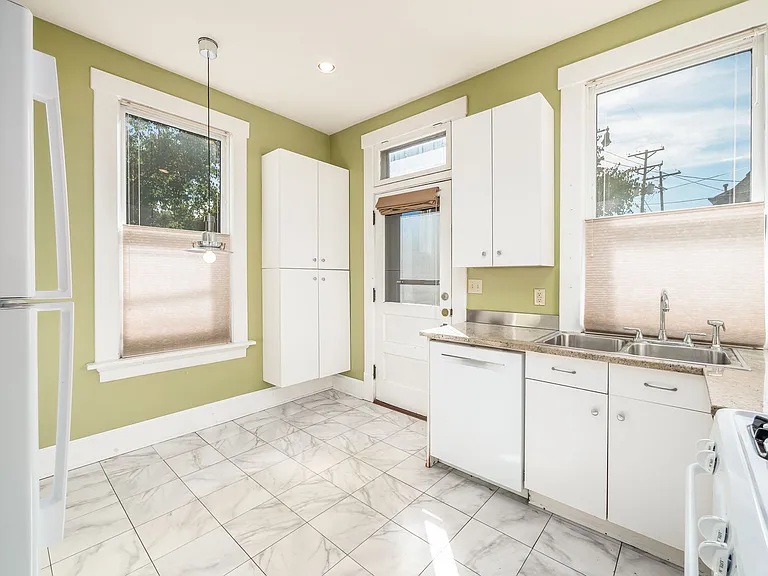 Kitchen with gas range, Bosch dishwasher, and plentiful storage with eating nook and access to the patio/deck. Paint color has been updated to a neutral.