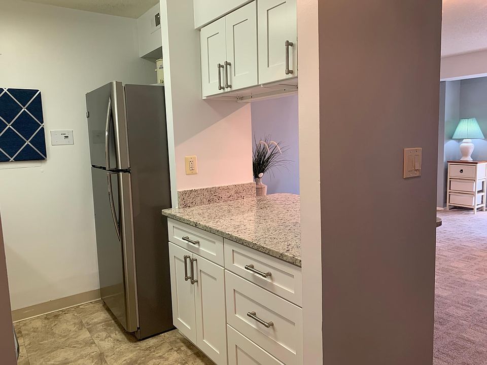 updated white kitchen with new stainless steel appliances and granite
