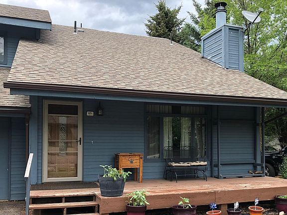 Front of the house with glider and woodpile rack.
