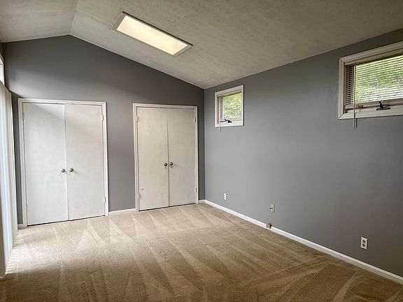 Large master suite with carpet floor and skylight