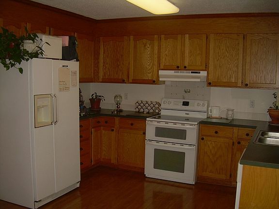 Kitchen has wood flooring, double oven, smooth top range and refridge stays.