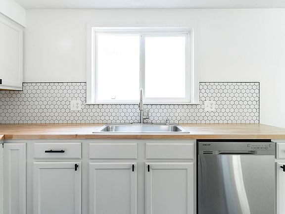 Updated kitchen with new butcher block countertops and backsplash.