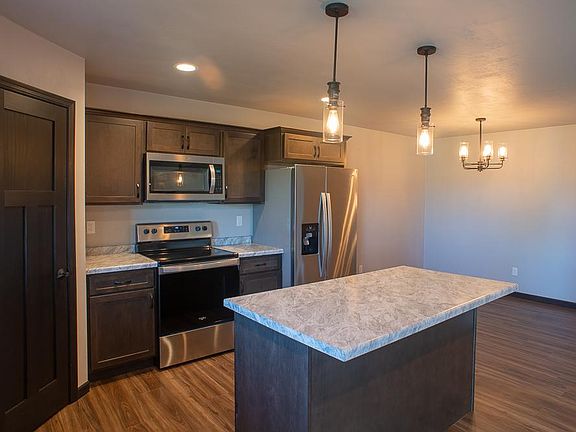 Open kitchen with modern lighting fixtures and appliances.