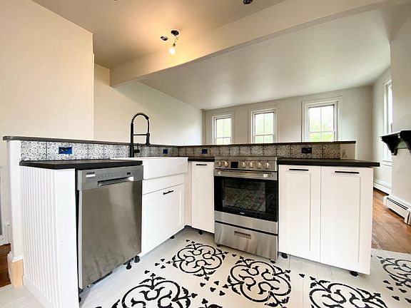 New kitchen with stainless steel appliances and hardwood floors