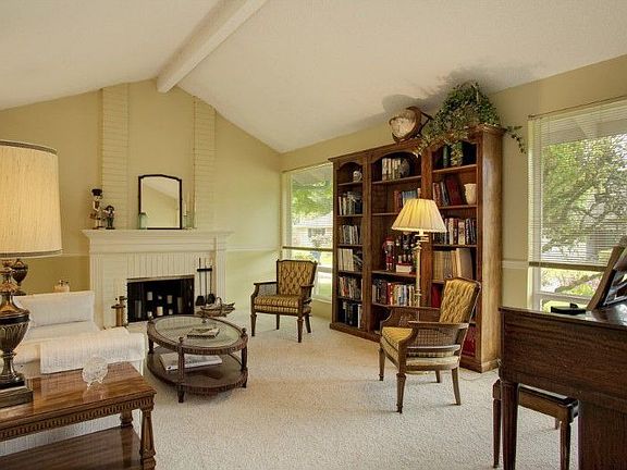 Large formal living room with vaulted ceilings, picture windows and fireplace.