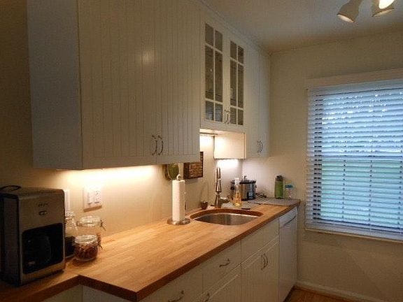 Galley kitchen has new white cabinetry