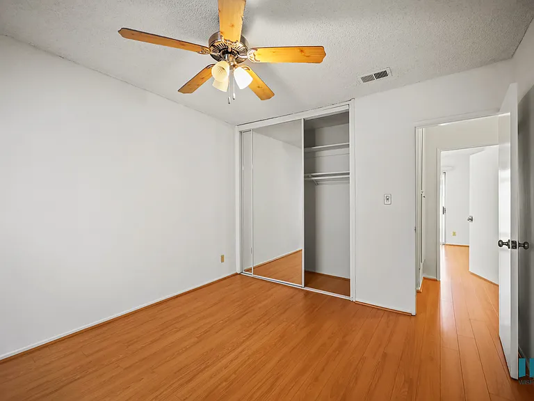 Bedroom with a Closet, Ceiling Fan, and Vinyl Flooring