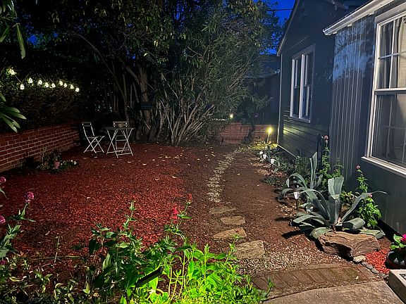 Front of the house at night with pathway lights.