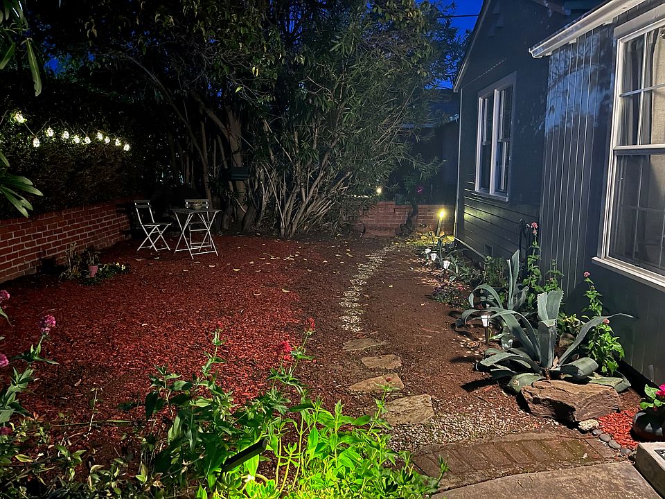 Front of the house at night with pathway lights.